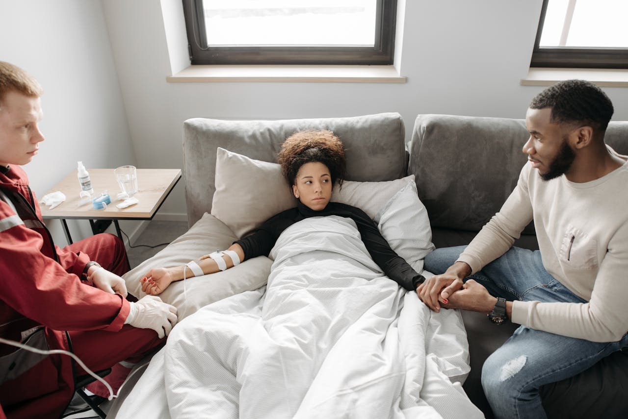 A caring family assisting a woman recovering at home with medical support from a paramedic.